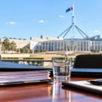 Temsili : Canberra'da parlamento binası önünde toplantı masası ve belgeler.