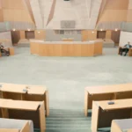 Avustralya tarzı bir parlamento salonunu gösteren, dijital güvenlik yasama sürecini temsil eden yatay.