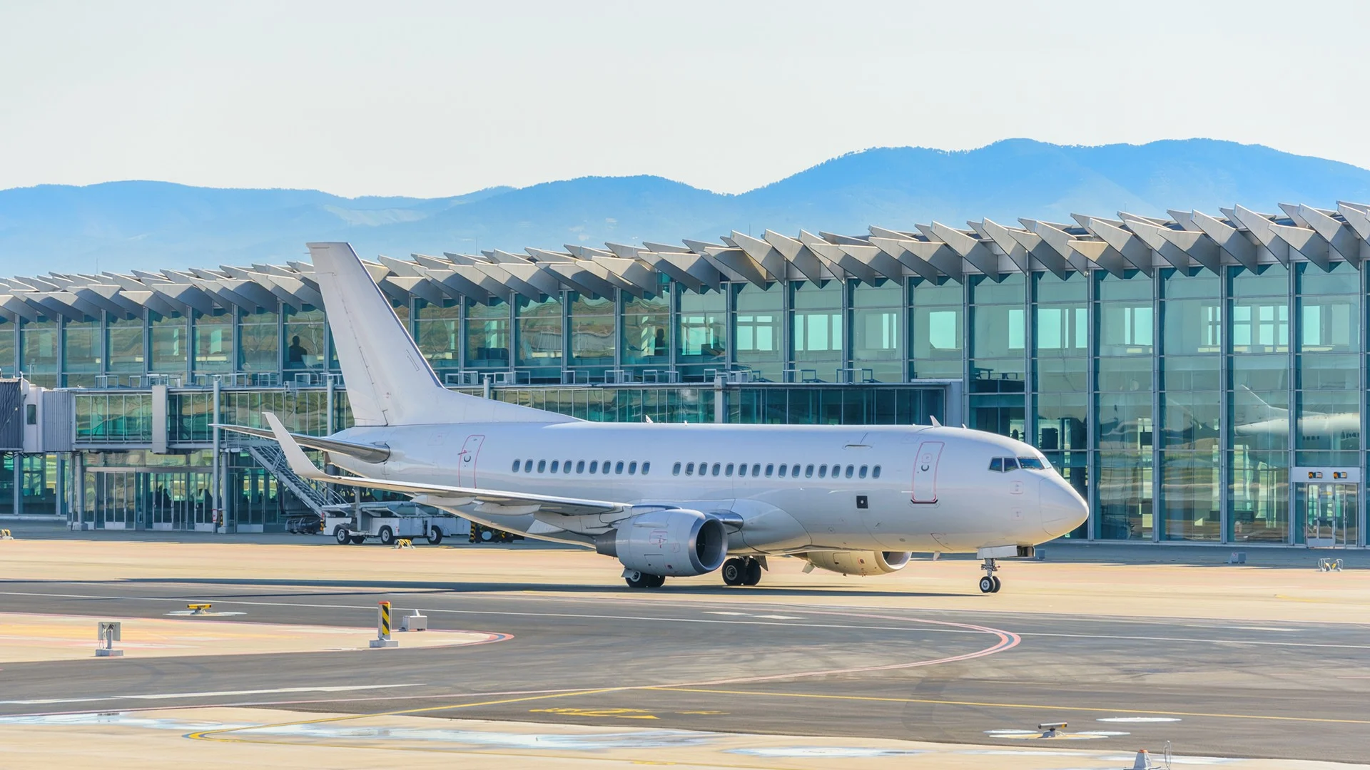 Temsili görüntü: modern bir havalimanında yolcu uçağı ve terminal.